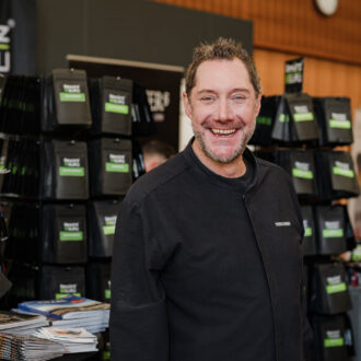 Foto: Starkoch Mirko Reeh präsentiert lächelnd seinen Messestand Gewürz Guru